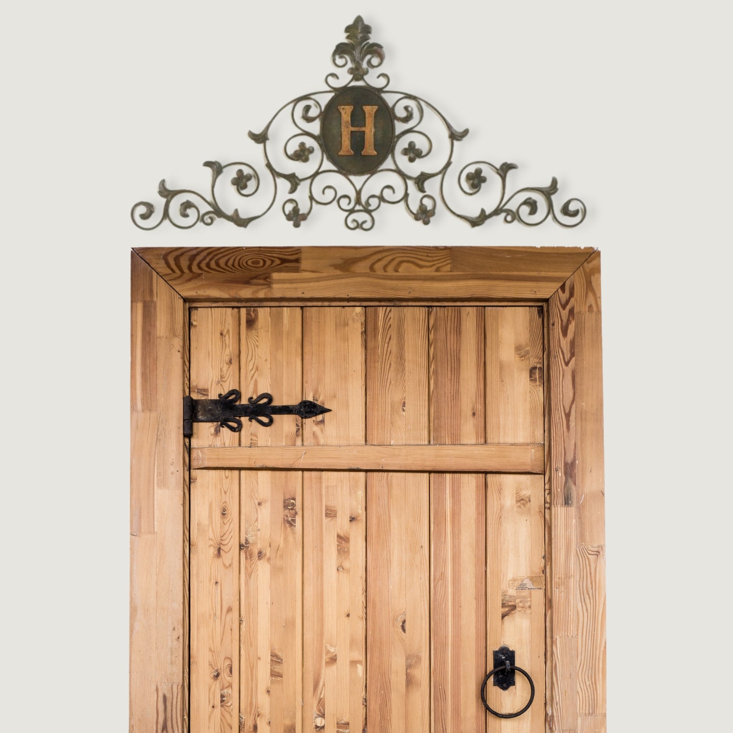 Leaf and Fleur de Lis Iron Monogram Wall Grille - Monogrammed Wall Decor (46.5"W) shown hung over rustic wood door with iron hardware | oak7west.com