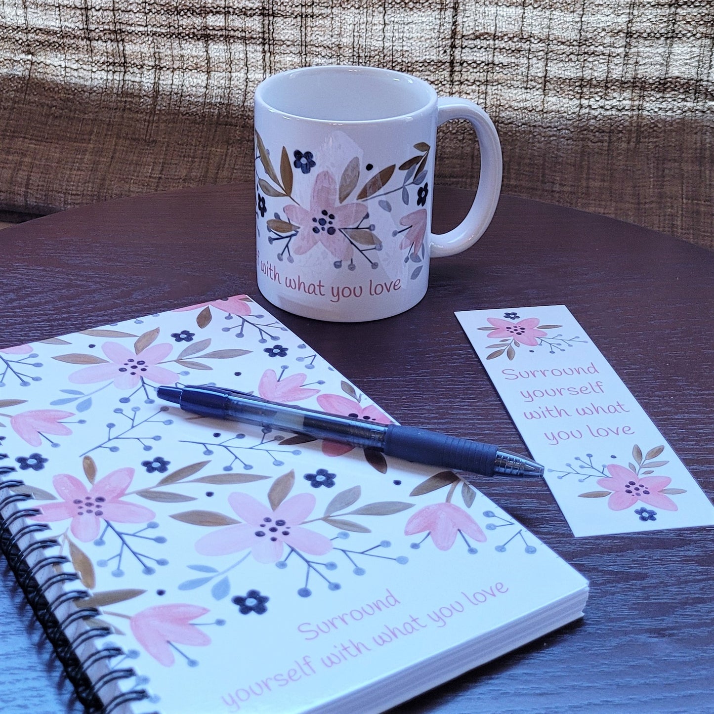 Surround yourself with what you love coffee mug (exclusive design) | lovely crisp white with a floral print in pinks, tans, and navy blue, finished off with the words "Surround yourself with what you love" in a fun pink font | 11 ounce coffee cup | shown with matching Surround yourself with what you love spiral notebook and bookmark | oak7west.com