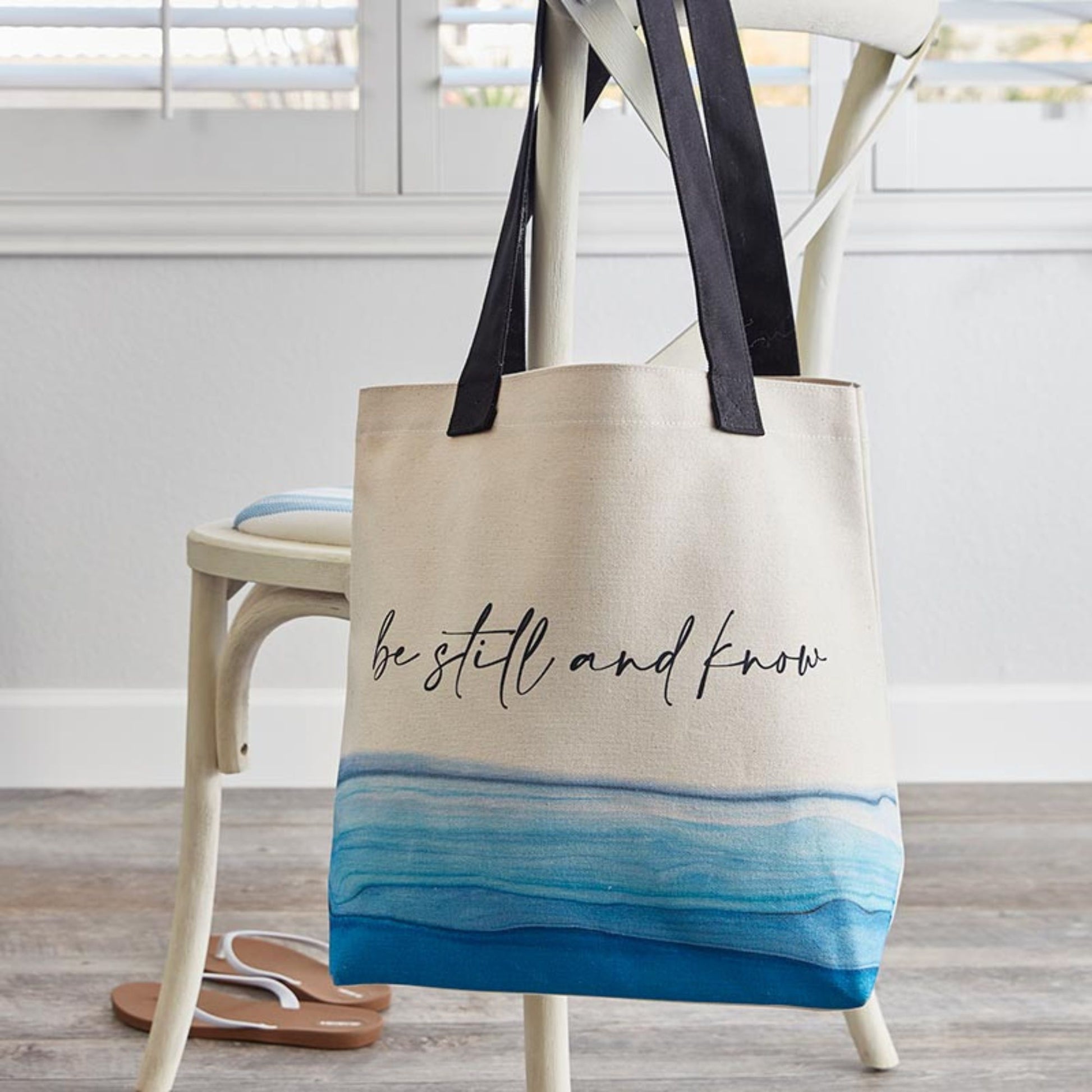 Canvas Tote Bag - Be Still and Know with calming blue wave design and black durable canvas straps hanging on dining chair | inside zippered pocket | oak7west.com