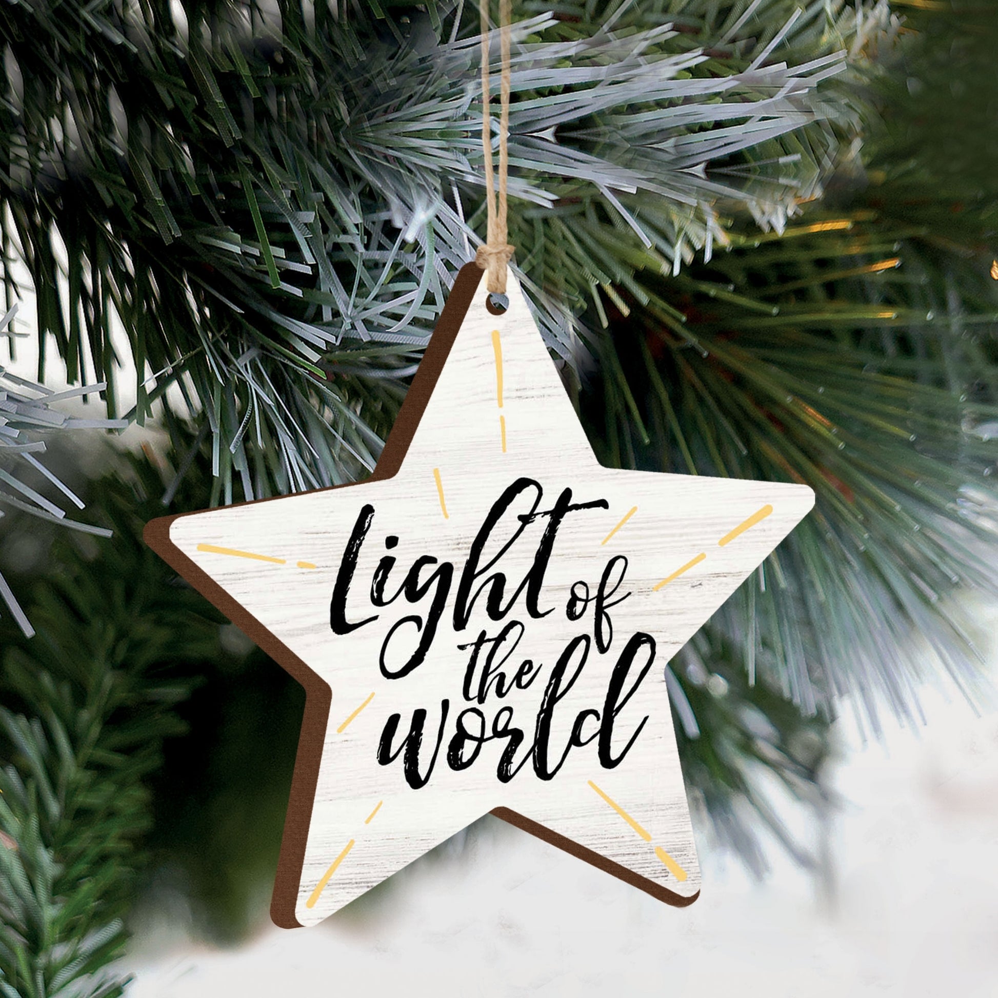 Star-shaped ornament with 'Light of the World' text hanging on a Christmas tree. | oak7west.com