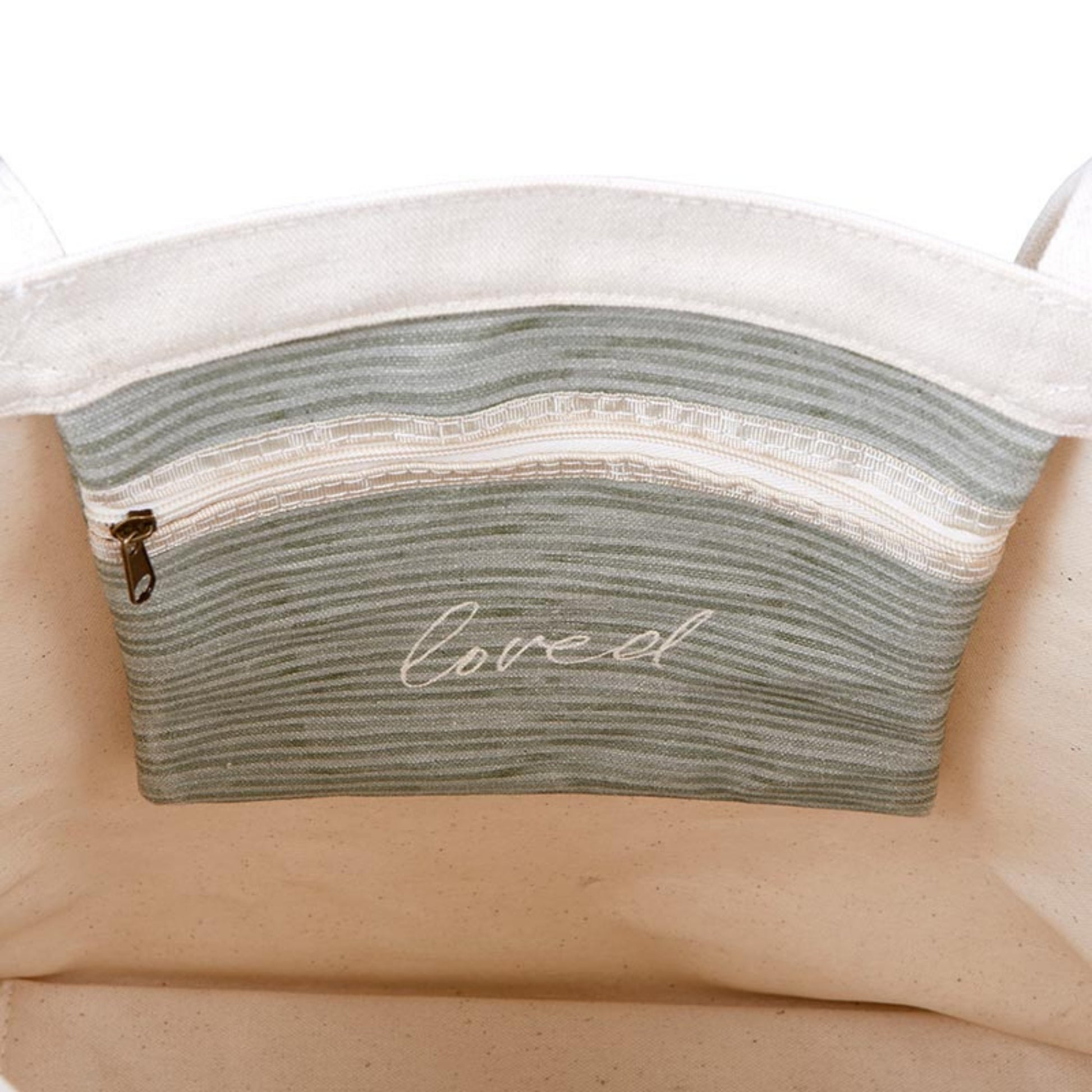 Close-up of zippered pouch inside green leaf design canvas tote with 'loved' printed for a daily reminder | oak7west.com