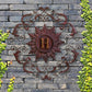 Decorative metal wall piece with 'H' on a stone wall surrounded by greenery | Monogrammed Iron Wall Grille - Personalized Wall Decor (33"W) | oak7west.com