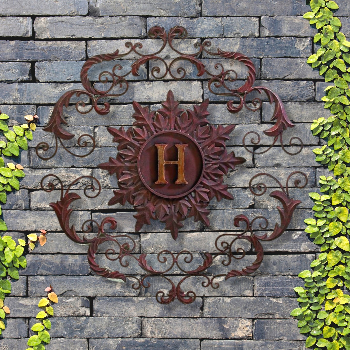 Decorative metal wall piece with 'H' on a stone wall surrounded by greenery | Monogrammed Iron Wall Grille - Personalized Wall Decor (33"W) | oak7west.com