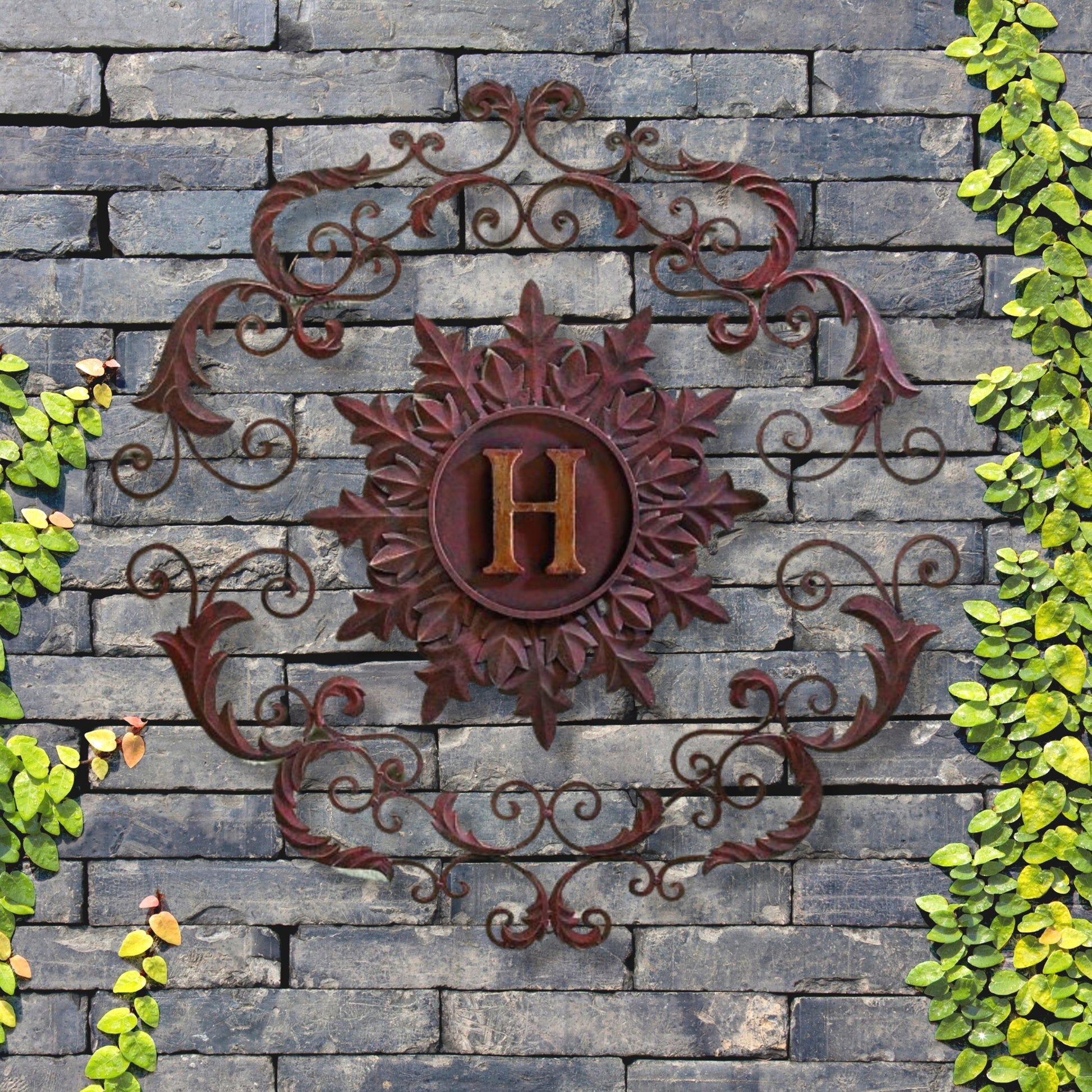 Decorative metal wall piece with 'H' on a stone wall surrounded by greenery | Monogrammed Iron Wall Grille - Personalized Wall Decor (33"W) | oak7west.com